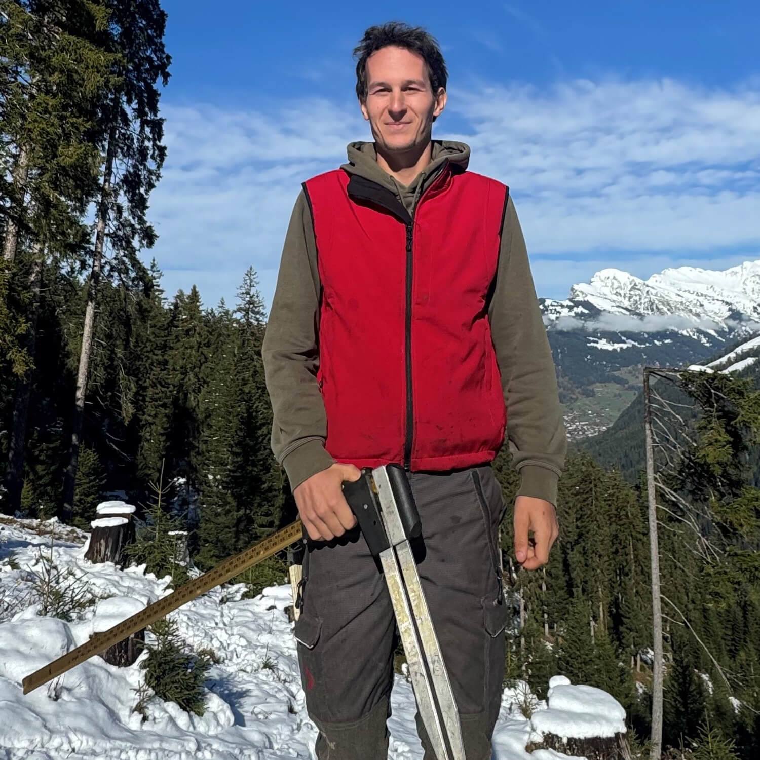 Mann mit Forstwerkzeug in einer winterlichenen Landschaft - Gion Gerber, Förster bei Hemmi Forst AG, Churwalden